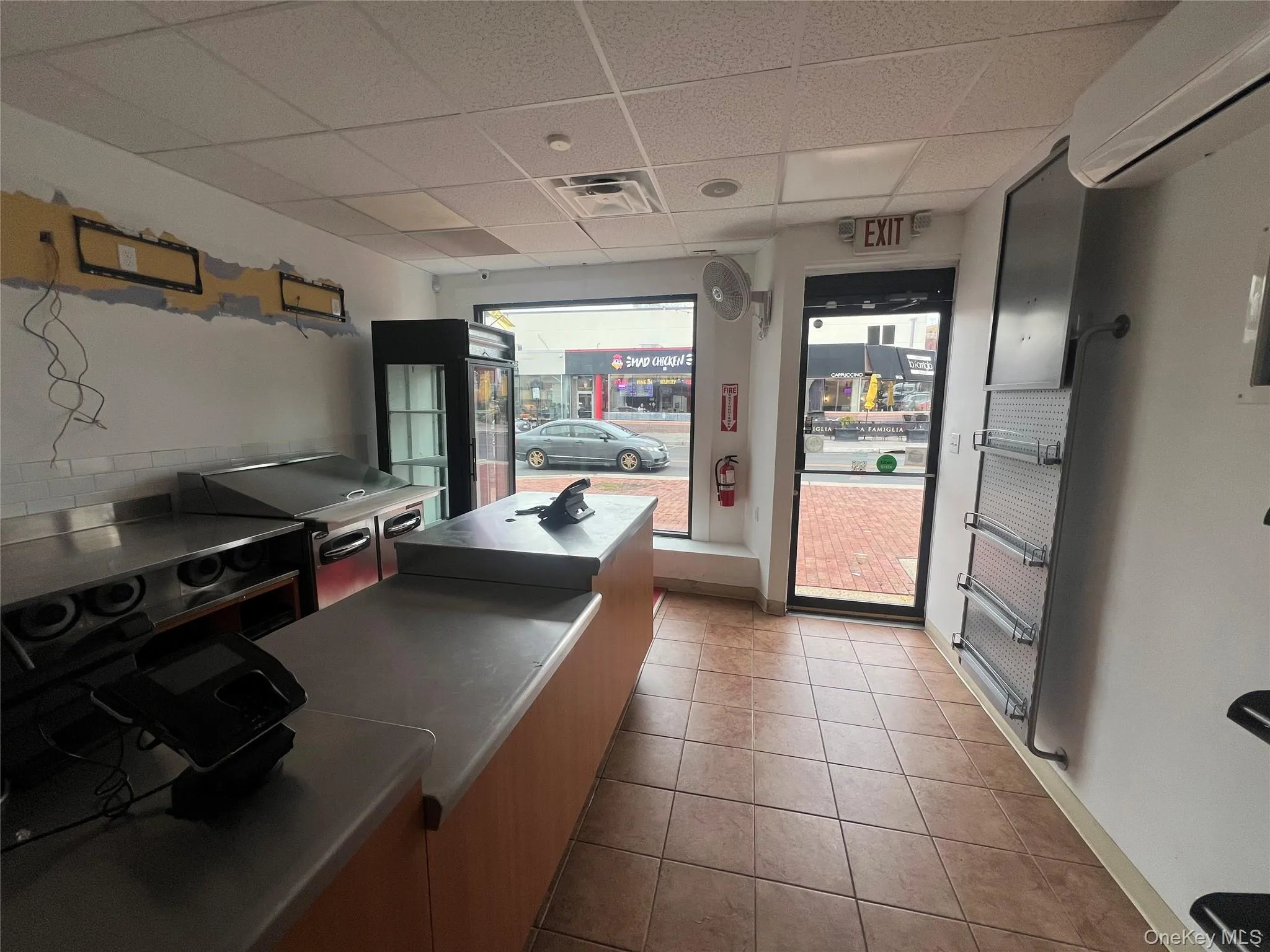 Kitchen featuring a paneled ceiling, a wall mounted air conditioner, and stainless steel countertops Kitchen featuring a paneled ceiling, a wall mounted air conditioner, and stainless steel countertops