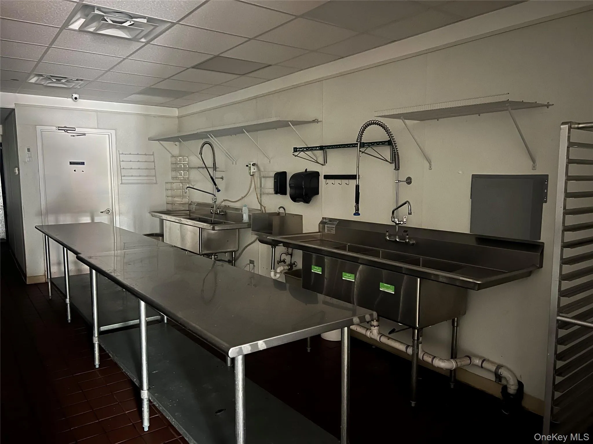 Kitchen featuring stainless steel counters and a paneled ceiling Kitchen featuring stainless steel counters and a paneled ceiling