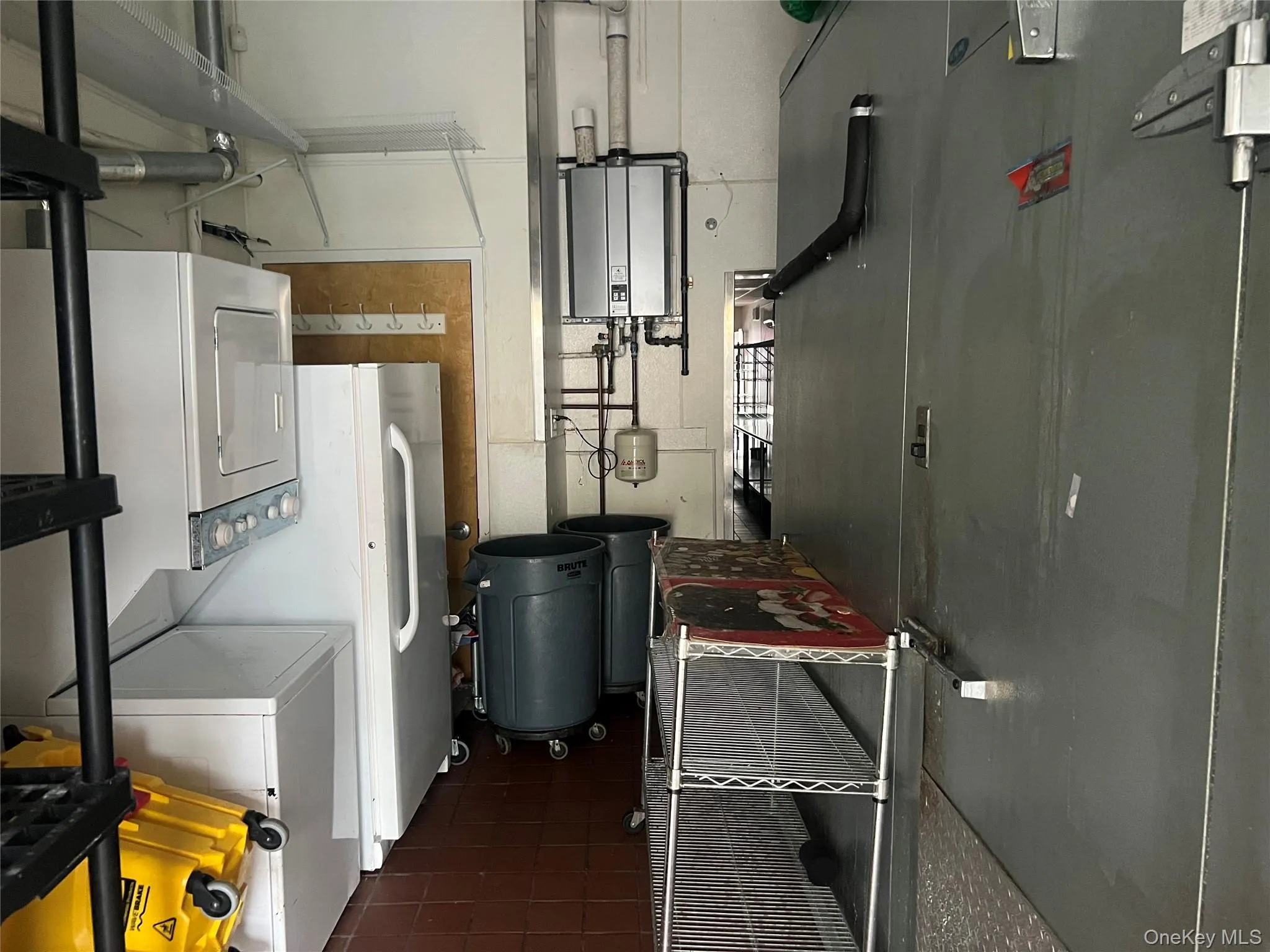 Utility room with stacked washing machine and dryer and tankless water heater Utility room with stacked washing machine and dryer and tankless water heater