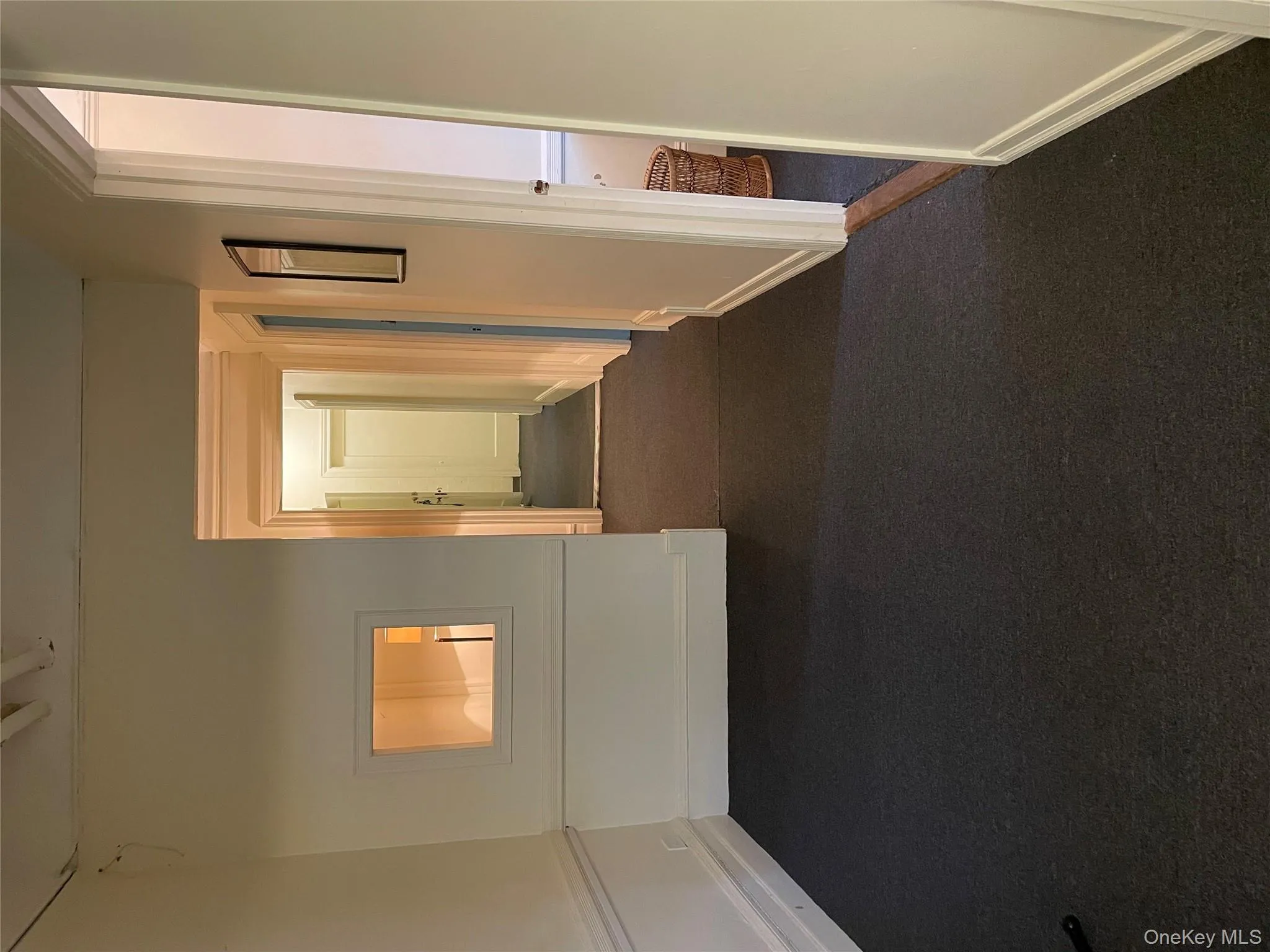 Hall featuring dark carpet and baseboards Hall featuring dark carpet and baseboards