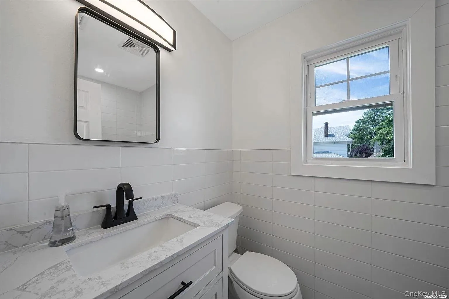 Half bathroom with vanity and tile walls Half bathroom with vanity and tile walls