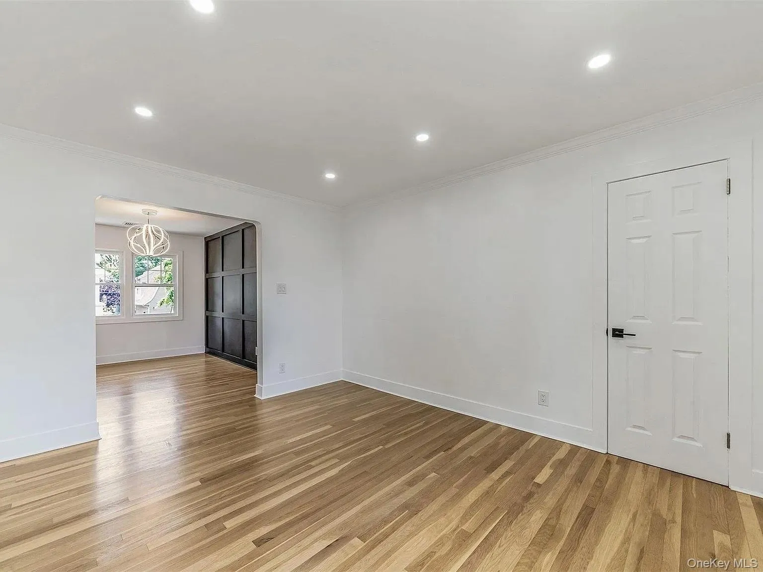 Empty room with light wood-type flooring, recessed lighting, and crown molding Empty room with light wood-type flooring, recessed lighting, and crown molding