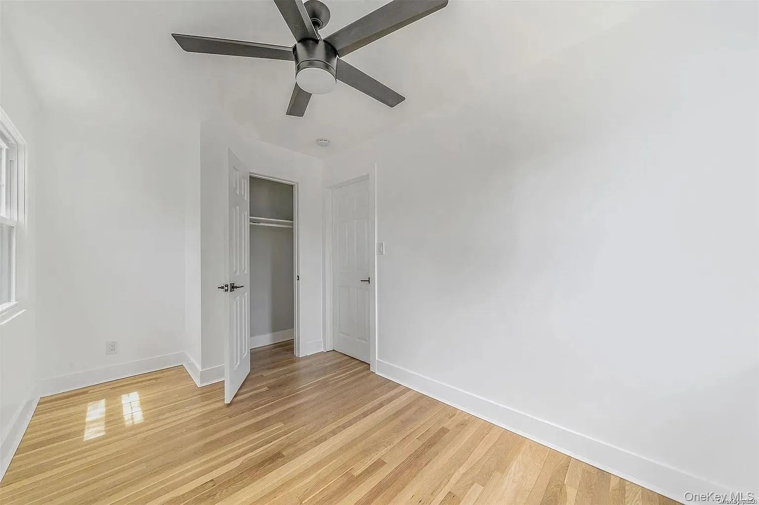 Unfurnished bedroom with a closet, light wood finished floors, and a ceiling fan Unfurnished bedroom with a closet, light wood finished floors, and a ceiling fan
