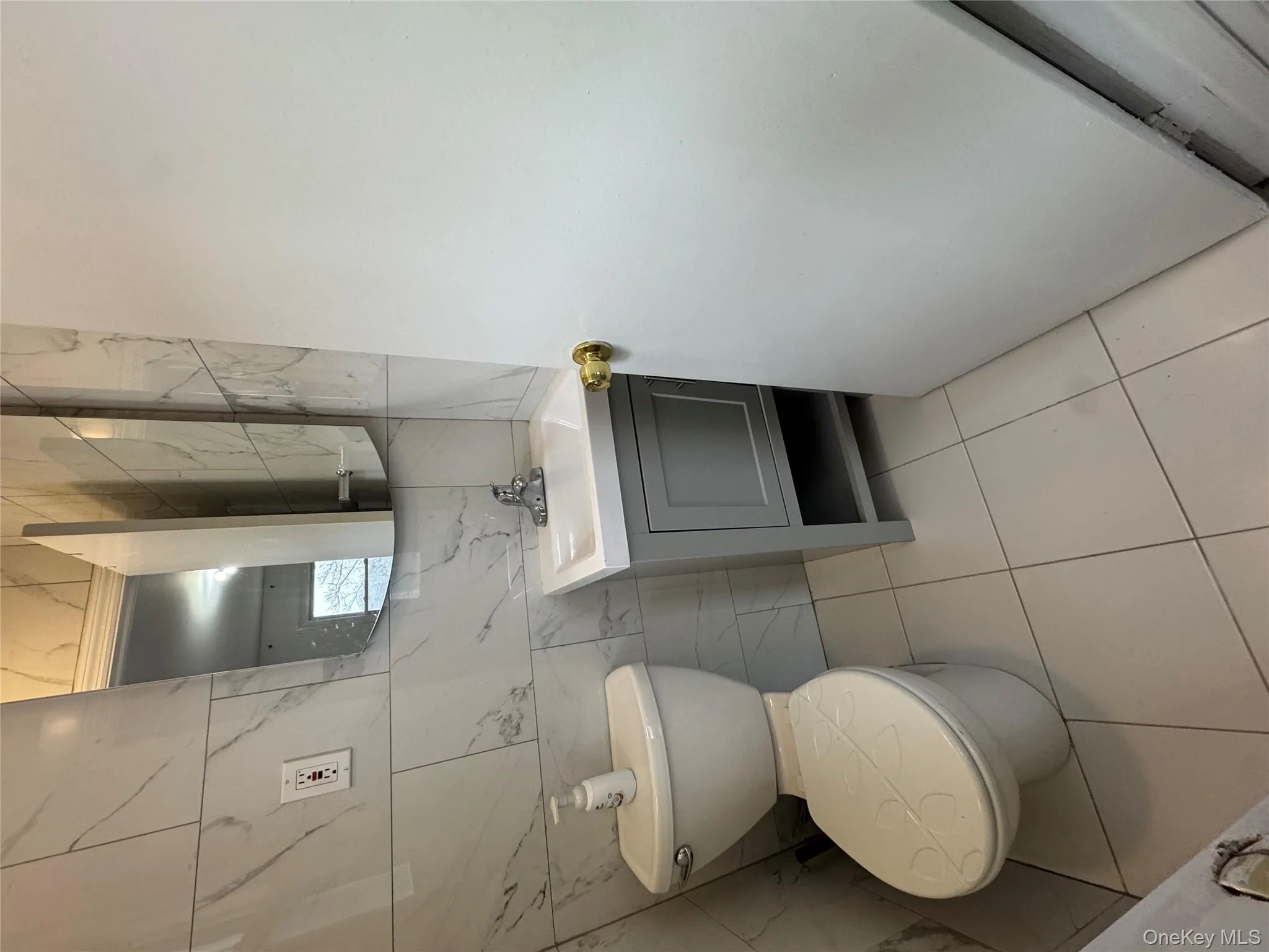 Bathroom featuring tile walls, vanity, and light tile patterned floors Bathroom featuring tile walls, vanity, and light tile patterned floors
