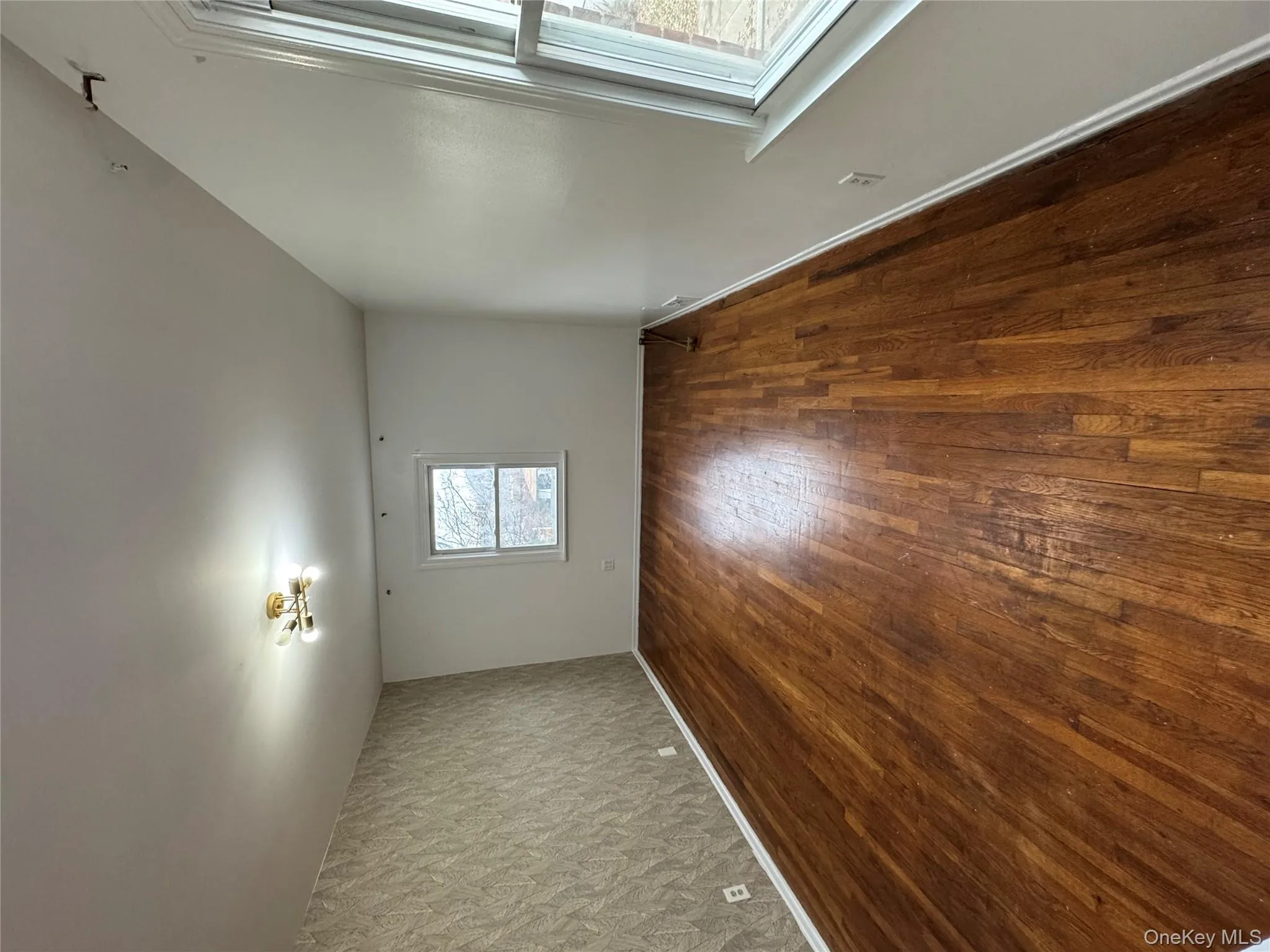 Unfurnished room with an accent wall, dark wood-type flooring, and wallpapered walls Unfurnished room with an accent wall, dark wood-type flooring, and wallpapered walls