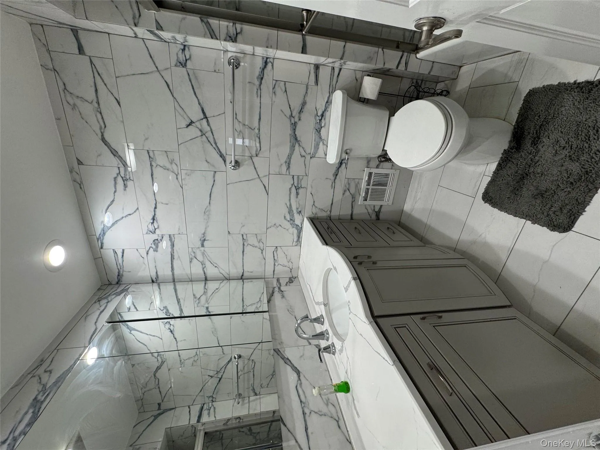 Full bath featuring tile walls, vanity, light marble finish flooring, recessed lighting, and a combined bath / shower with marble appearance Full bath featuring tile walls, vanity, light marble finish flooring, recessed lighting, and a combined bath / shower with marble appearance