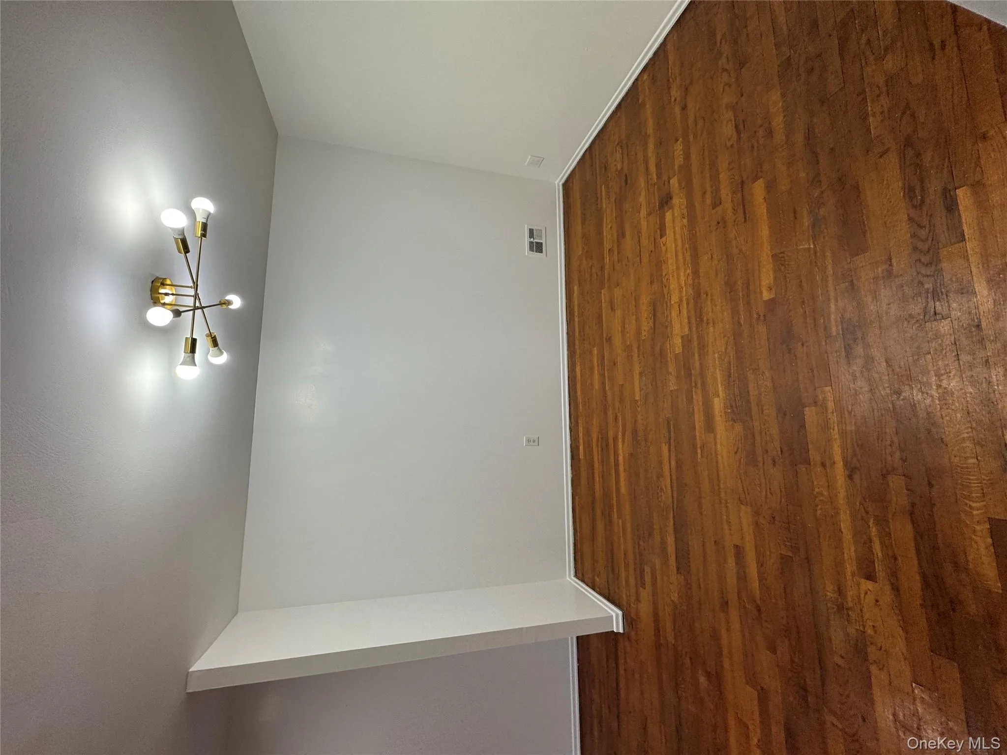 Empty room featuring dark wood finished floors and a chandelier Empty room featuring dark wood finished floors and a chandelier