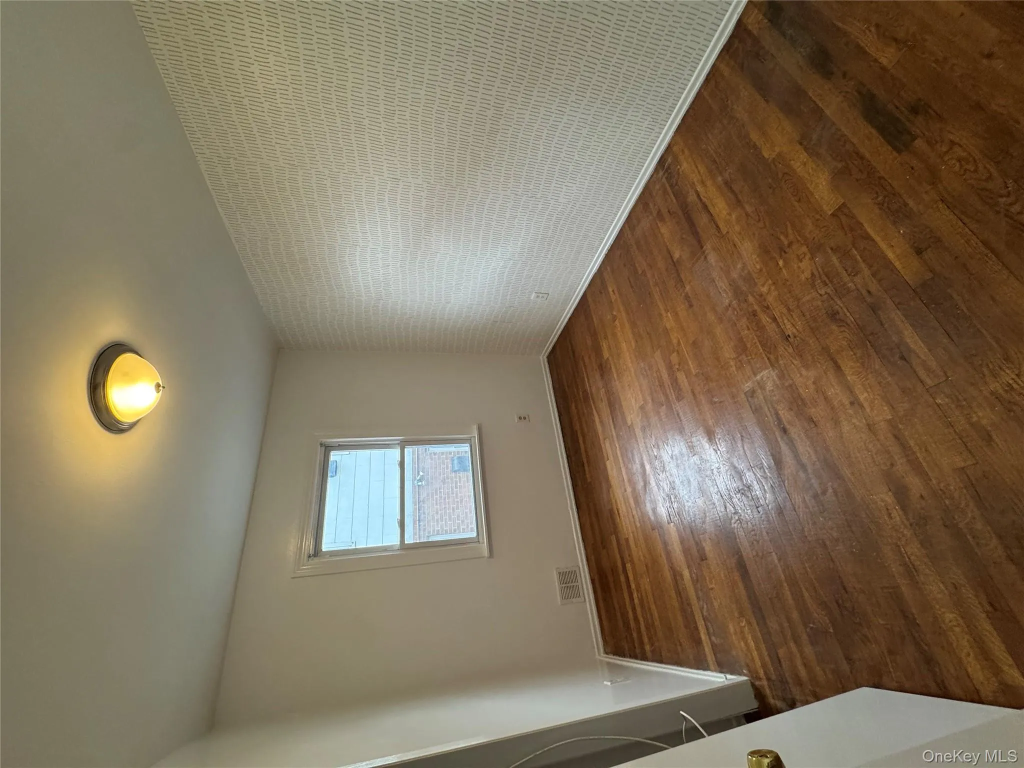 Unfurnished room with dark wood-style floors and an accent wall Unfurnished room with dark wood-style floors and an accent wall