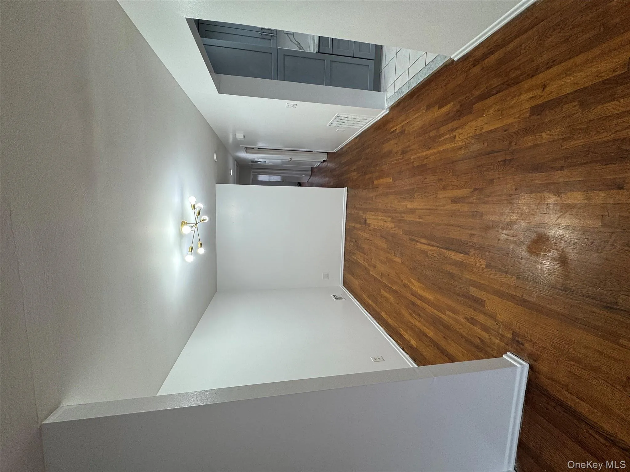 Spare room with dark wood finished floors, a chandelier, and a textured ceiling Spare room with dark wood finished floors, a chandelier, and a textured ceiling