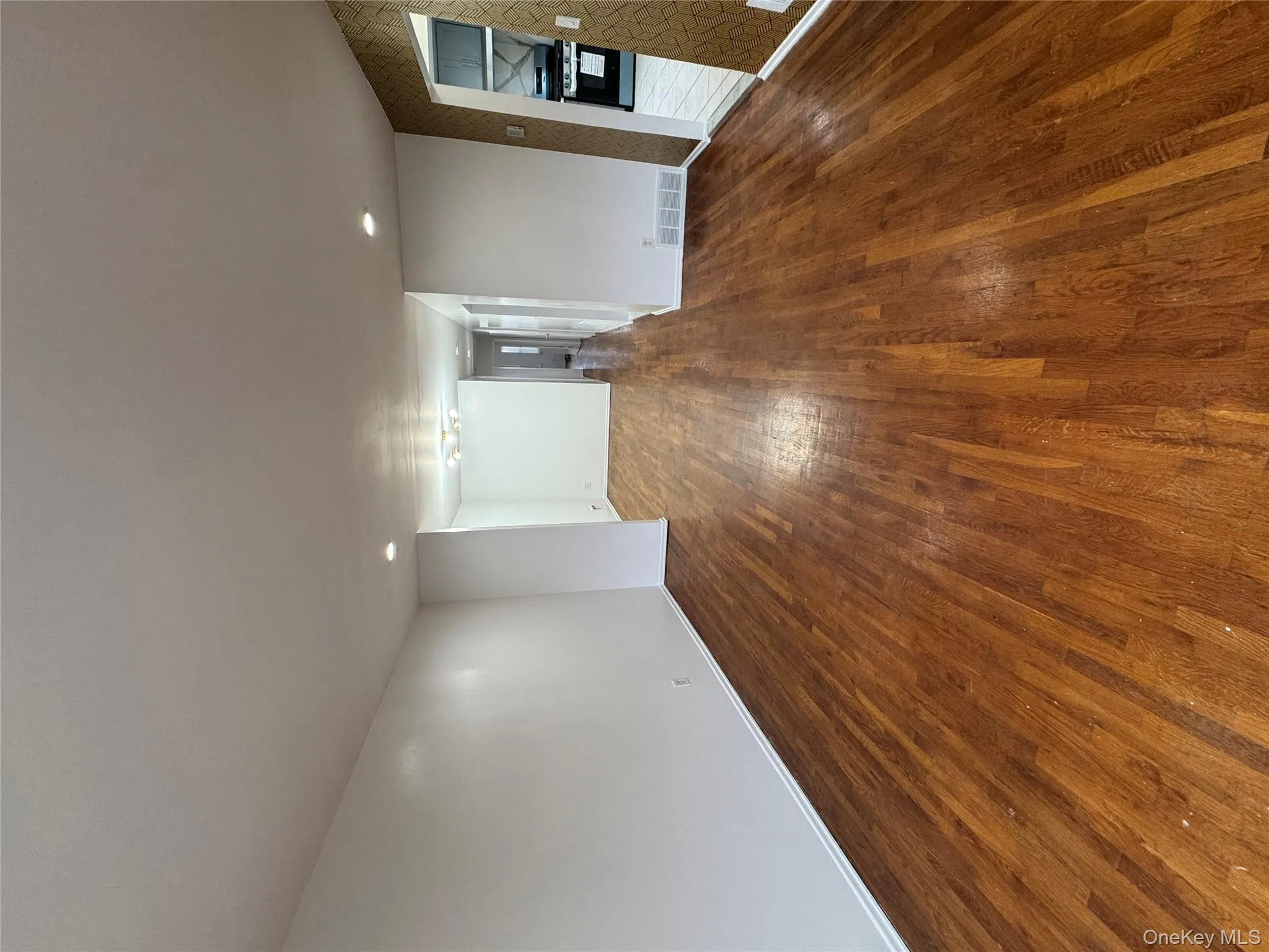 Unfurnished room with dark wood-style floors, recessed lighting, and wallpapered walls Unfurnished room with dark wood-style floors, recessed lighting, and wallpapered walls