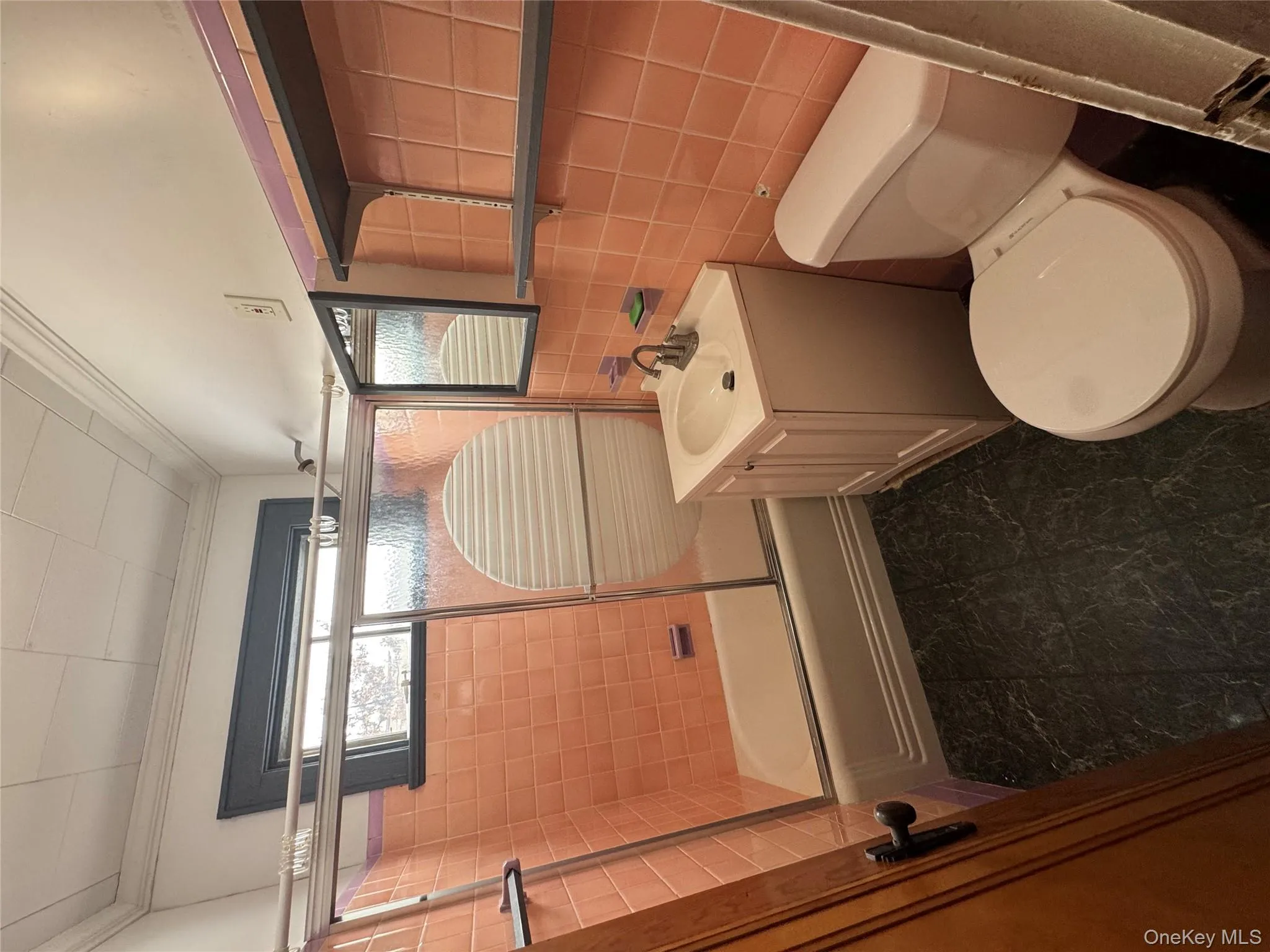 Full bath with bath / shower combo with glass door, vanity, tile walls, and ornamental molding Full bath with bath / shower combo with glass door, vanity, tile walls, and ornamental molding