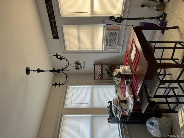 Dining space featuring healthy amount of natural light, light tile patterned flooring, a chandelier, and cooling unit Dining space featuring healthy amount of natural light, light tile patterned flooring, a chandelier, and cooling unit