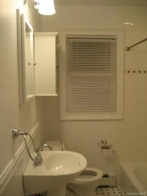 Bathroom featuring bathtub / shower combination and a baseboard radiator Bathroom featuring bathtub / shower combination and a baseboard radiator