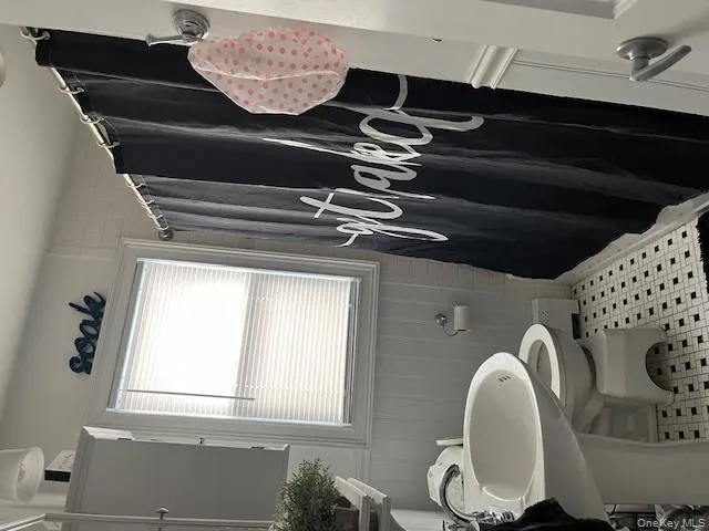 Bathroom with light tile patterned floors and a baseboard radiator Bathroom with light tile patterned floors and a baseboard radiator