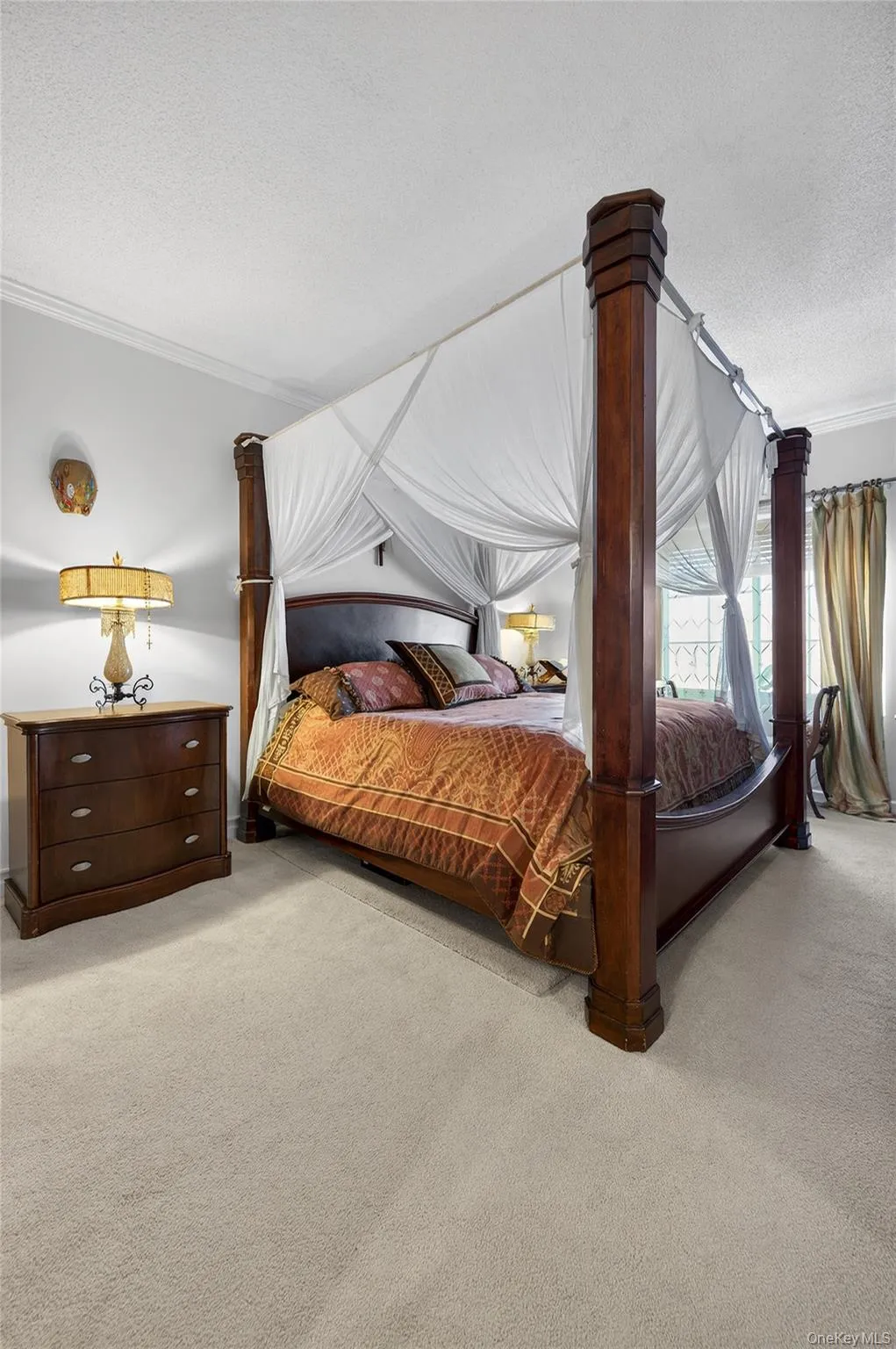Bedroom featuring crown molding, a textured ceiling, and carpet Bedroom featuring crown molding, a textured ceiling, and carpet