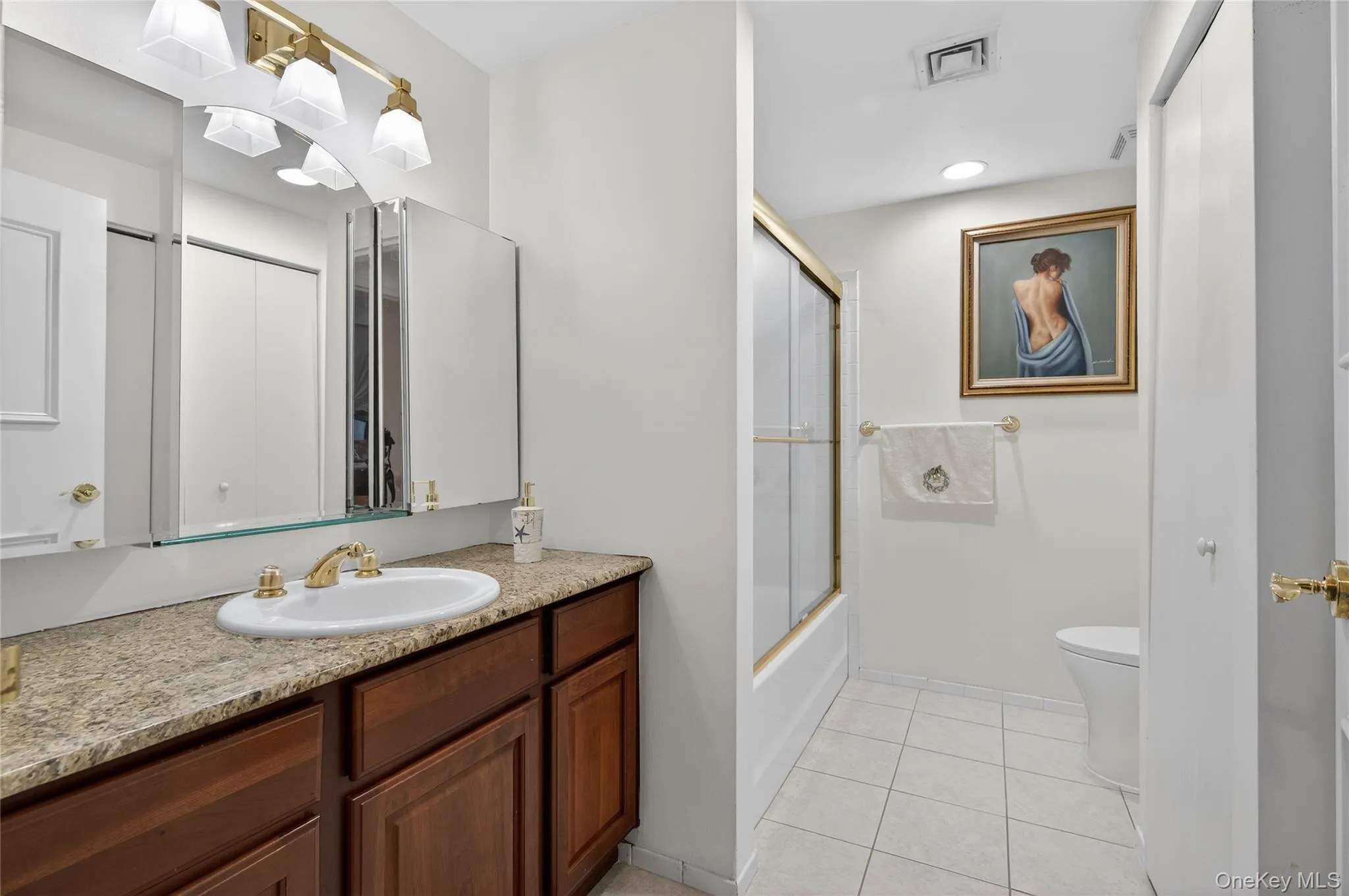 Bathroom featuring vanity, light tile patterned floors, shower / bath combination with glass door, and recessed lighting Bathroom featuring vanity, light tile patterned floors, shower / bath combination with glass door, and recessed lighting