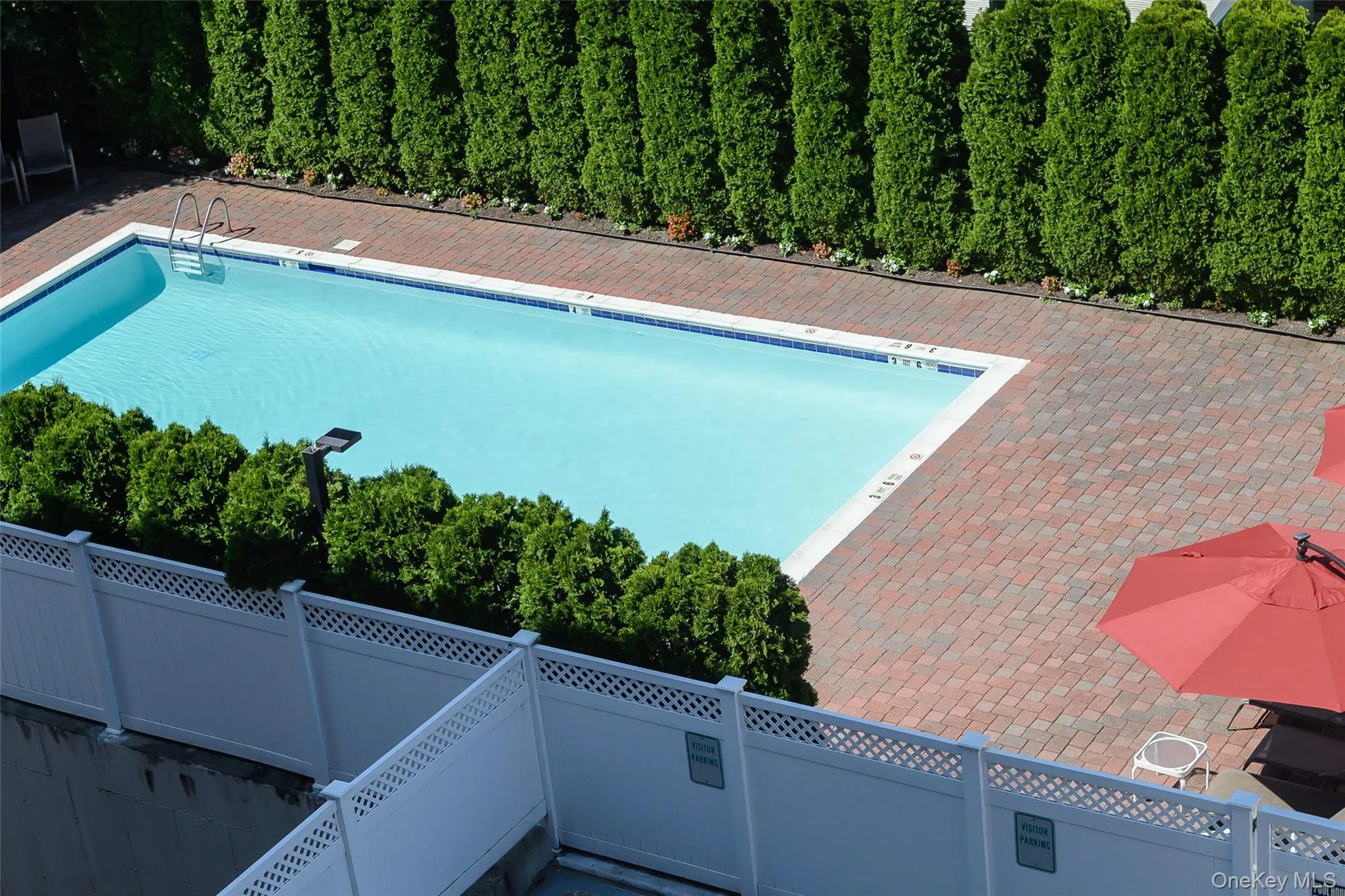 Community pool with a fenced backyard and a patio Community pool with a fenced backyard and a patio