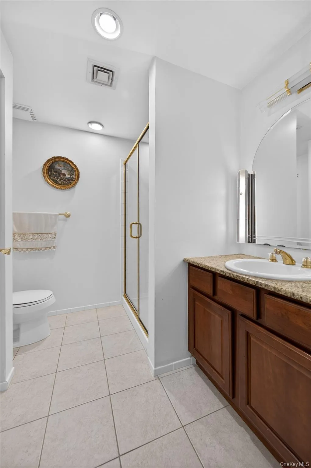 Full bathroom featuring a stall shower, vanity, and light tile patterned flooring Full bathroom featuring a stall shower, vanity, and light tile patterned flooring