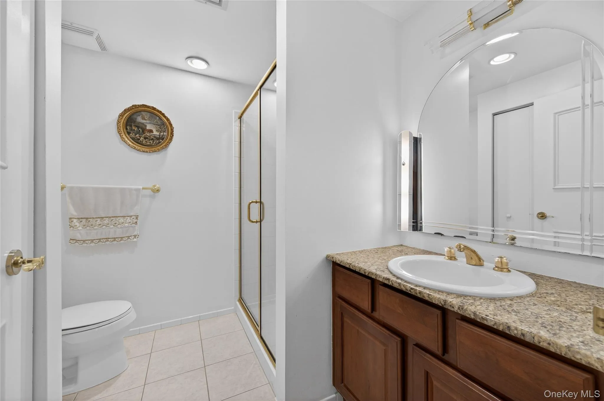 Bathroom featuring vanity, a stall shower, and light tile patterned flooring Bathroom featuring vanity, a stall shower, and light tile patterned flooring