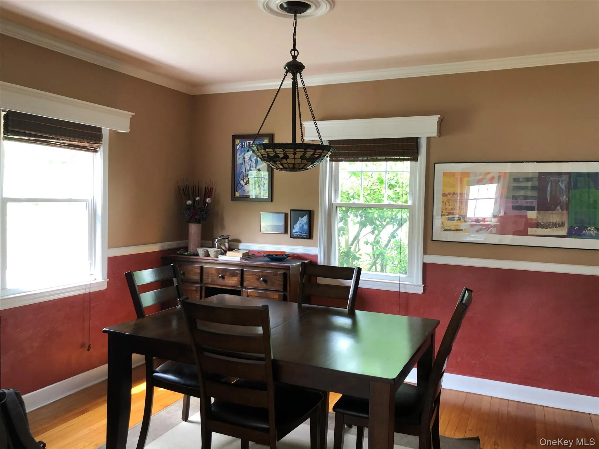 Dining room featuring wood finished floors and crown molding Dining room featuring wood finished floors and crown molding