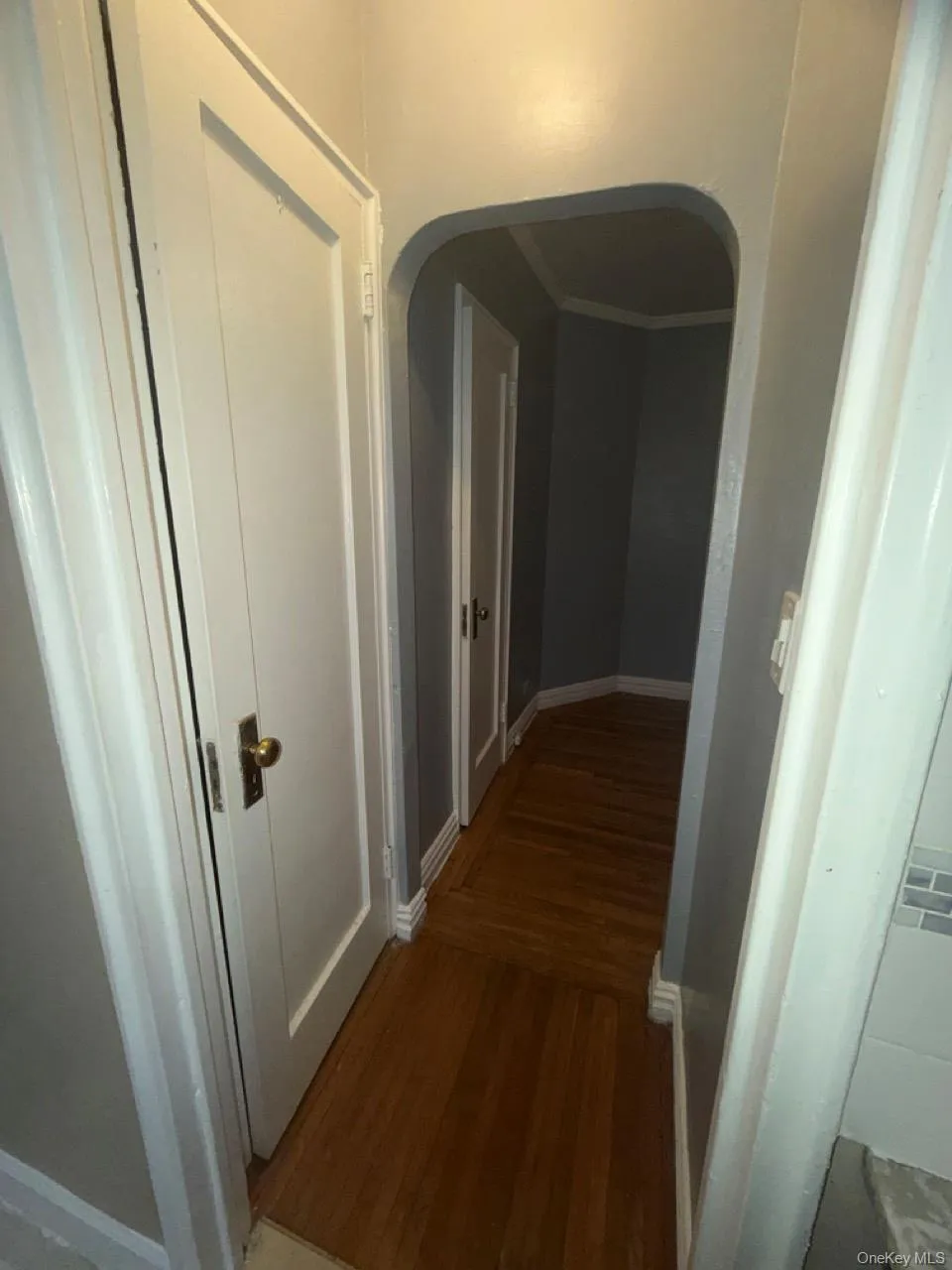 Hall with wood finished floors, arched walkways, and molding Hall with wood finished floors, arched walkways, and molding