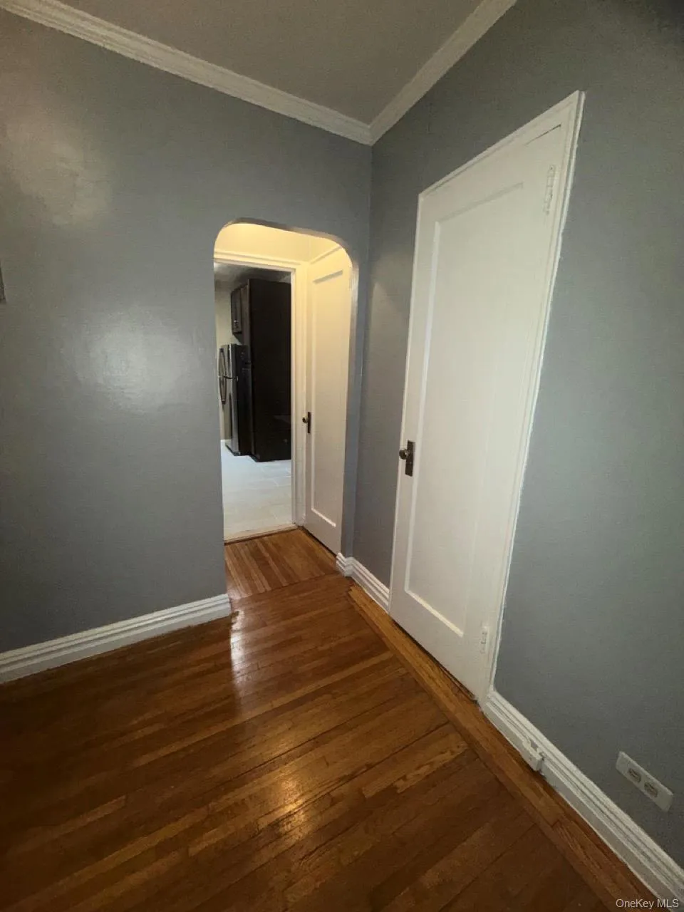 Hall featuring arched walkways, dark hardwood floors, and crown molding Hall featuring arched walkways, dark hardwood floors, and crown molding