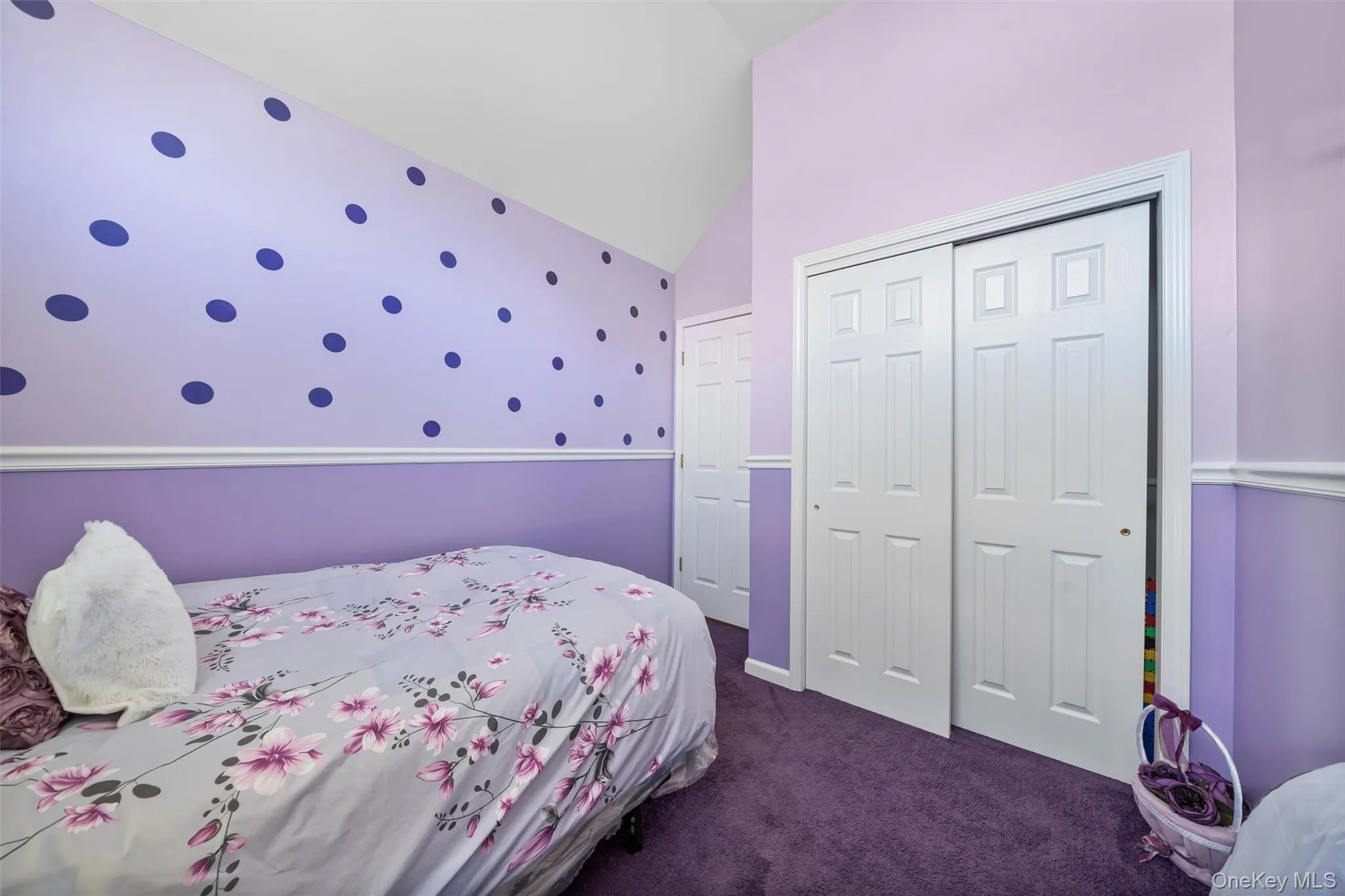 Bedroom with dark carpet, lofted ceiling, and a closet Bedroom with dark carpet, lofted ceiling, and a closet