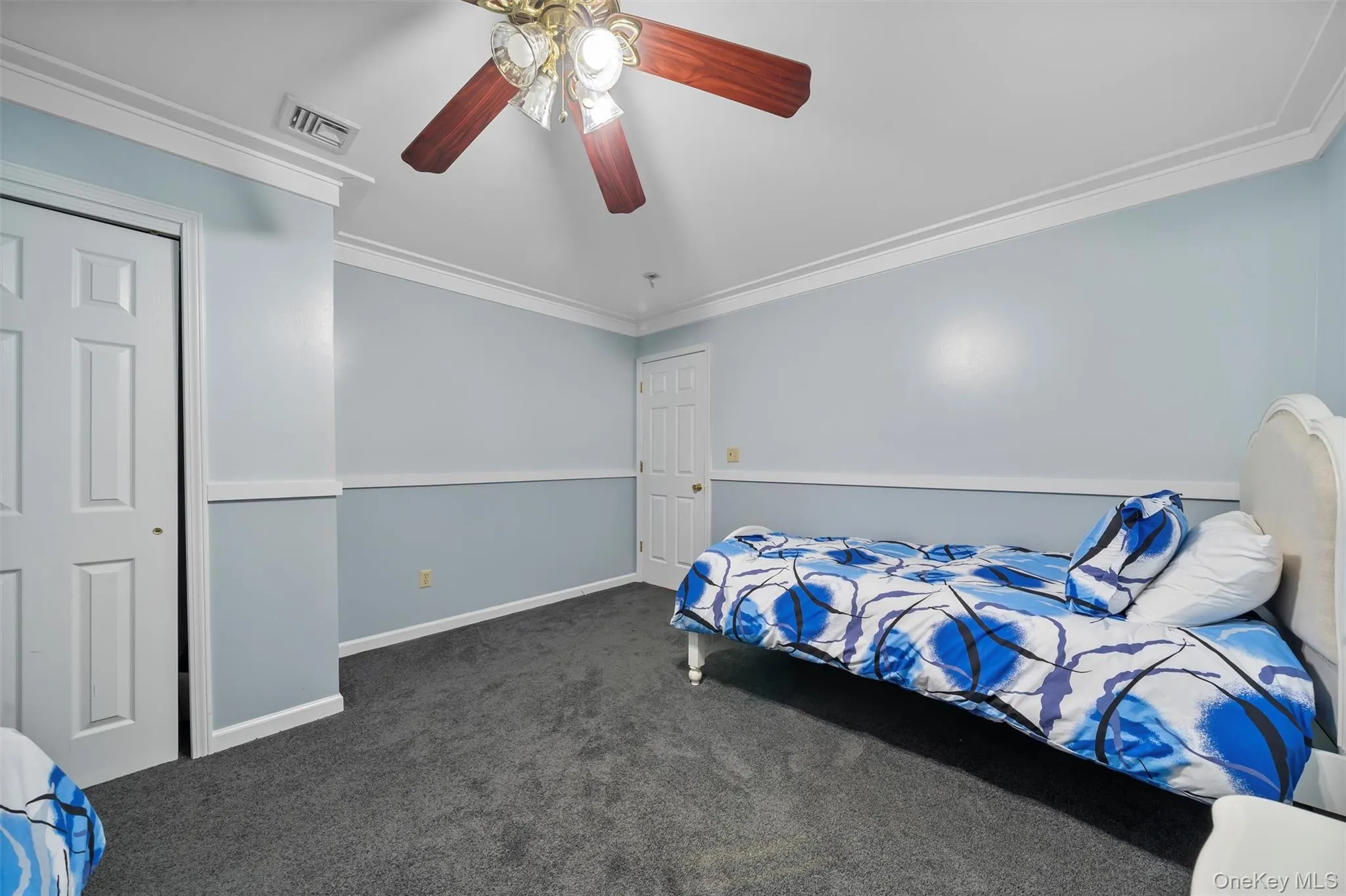 Bedroom with crown molding, carpet, and a ceiling fan Bedroom with crown molding, carpet, and a ceiling fan