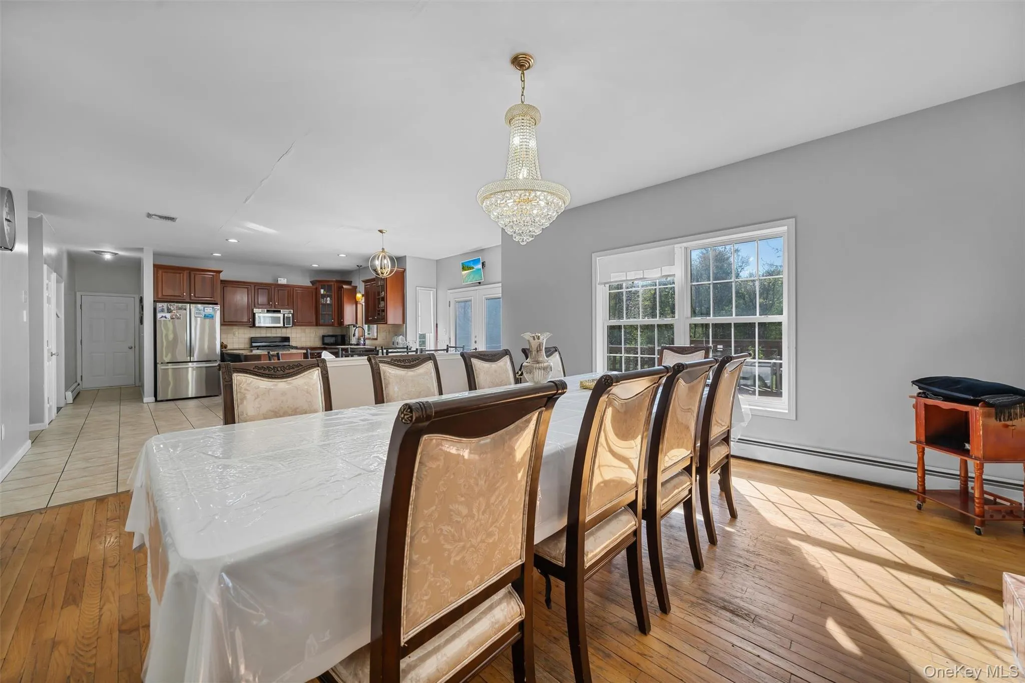 Dining space with a chandelier, a baseboard heating unit, light wood-style flooring, and recessed lighting Dining space with a chandelier, a baseboard heating unit, light wood-style flooring, and recessed lighting
