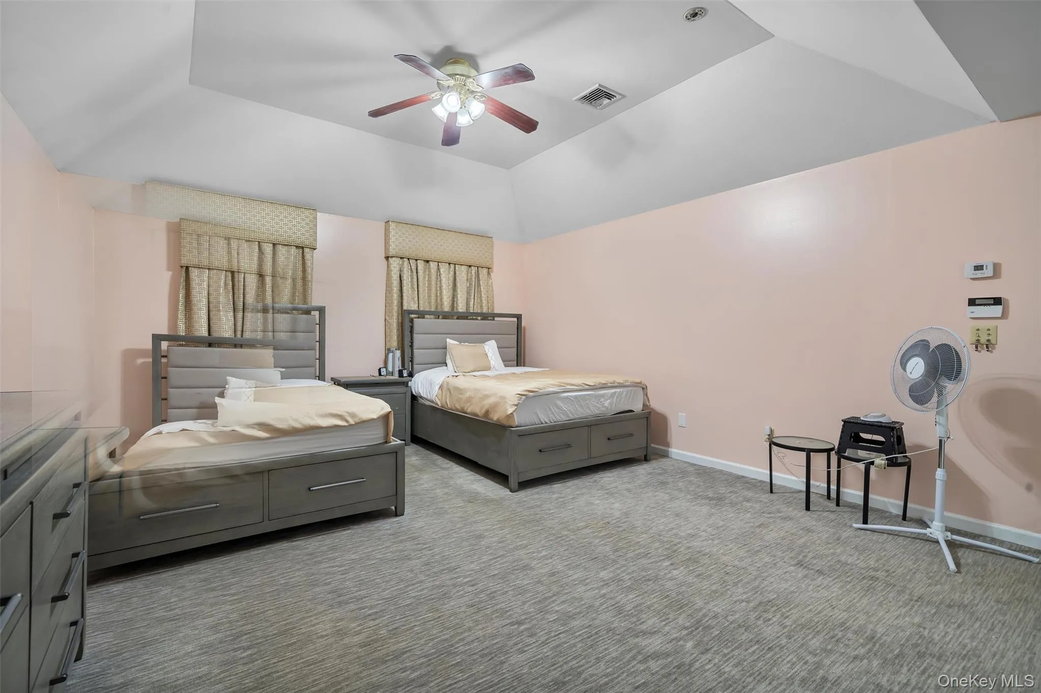 Carpeted bedroom featuring a ceiling fan and lofted ceiling Carpeted bedroom featuring a ceiling fan and lofted ceiling