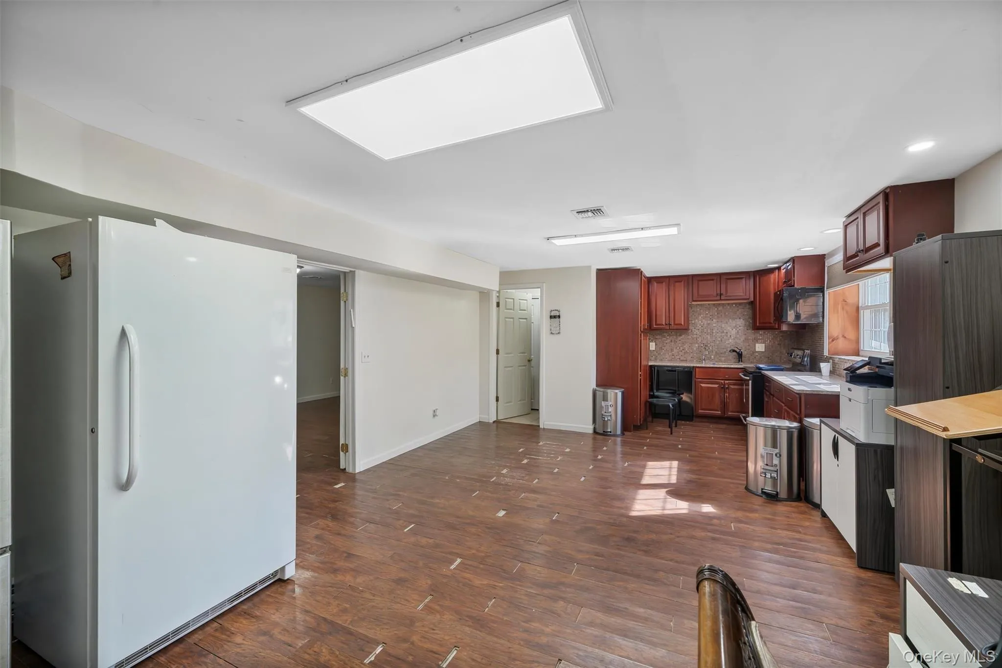 Kitchen featuring light countertops, black appliances, dark wood-style floors, and tasteful backsplash Kitchen featuring light countertops, black appliances, dark wood-style floors, and tasteful backsplash