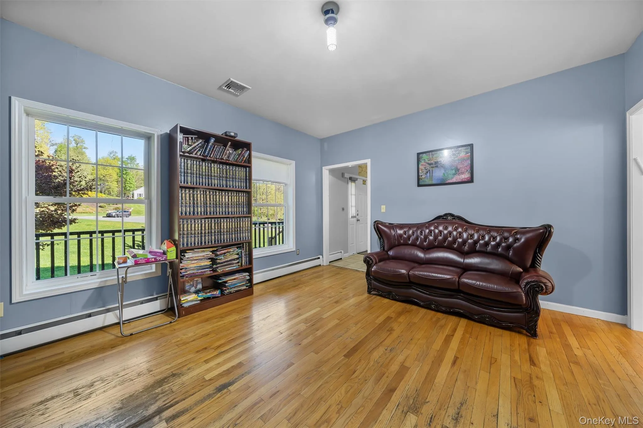 Living area featuring light wood-style floors, a baseboard radiator, and a baseboard heating unit Living area featuring light wood-style floors, a baseboard radiator, and a baseboard heating unit
