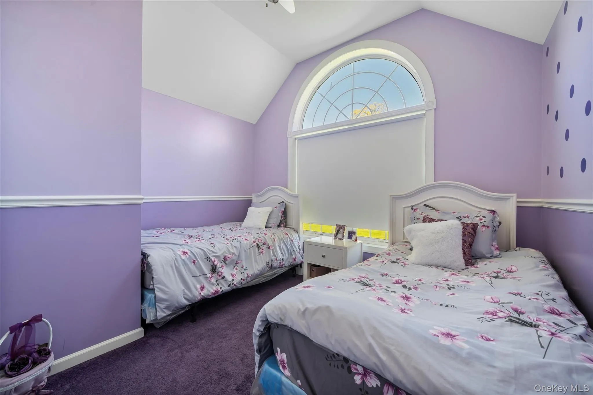 Bedroom featuring vaulted ceiling, dark colored carpet, and a ceiling fan Bedroom featuring vaulted ceiling, dark colored carpet, and a ceiling fan