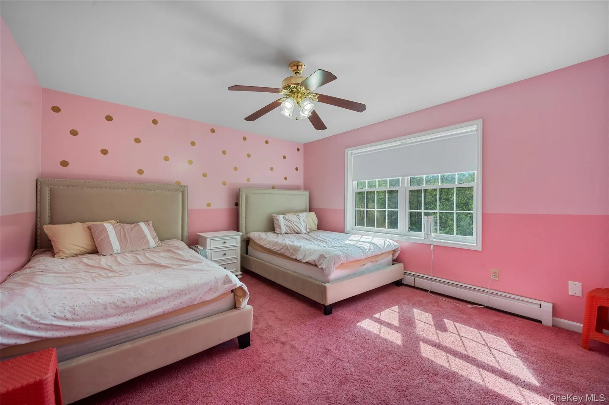 Carpeted bedroom featuring a baseboard radiator, wallpapered walls, a ceiling fan, and an accent wall Carpeted bedroom featuring a baseboard radiator, wallpapered walls, a ceiling fan, and an accent wall