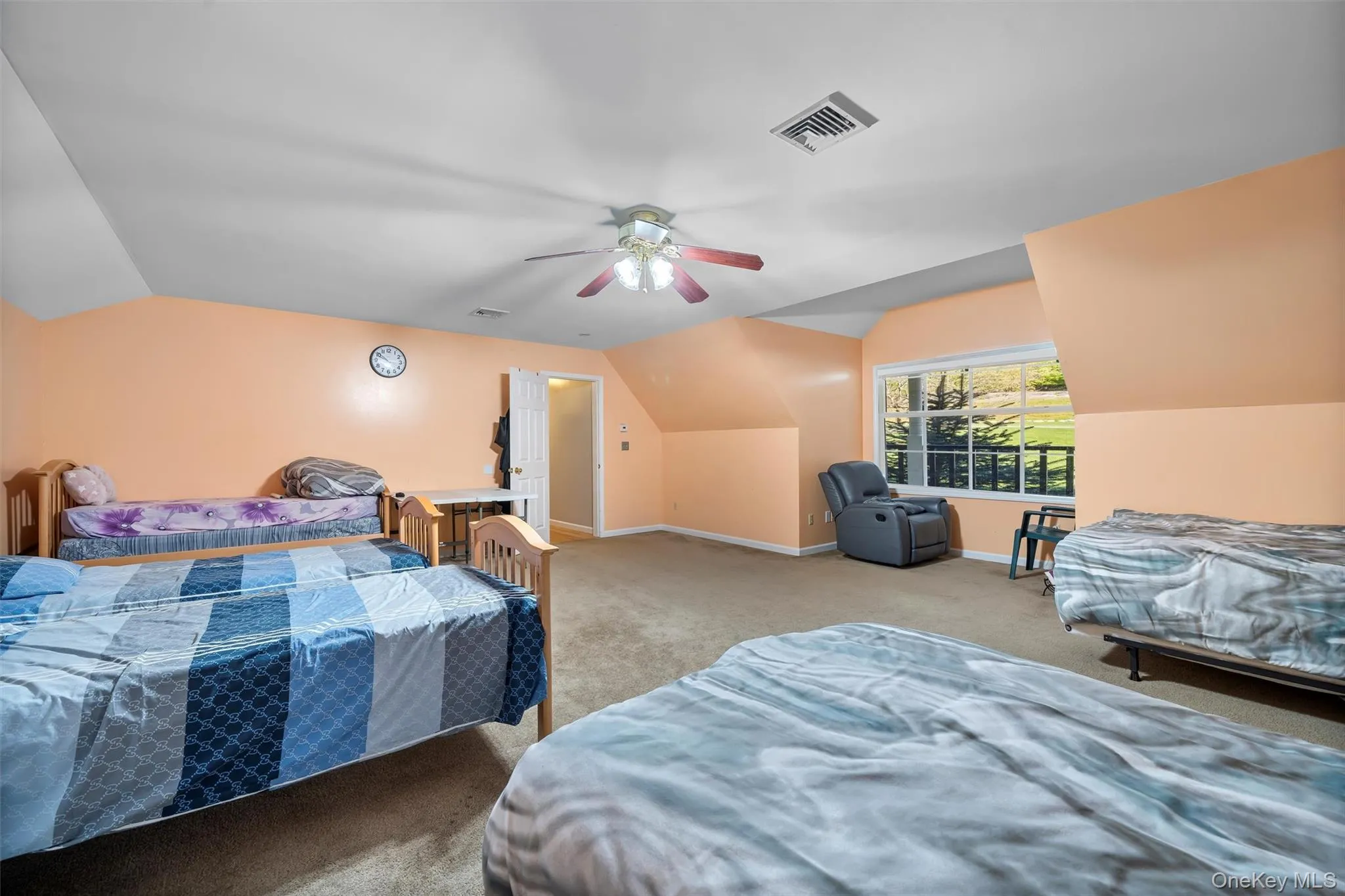 Carpeted bedroom with vaulted ceiling and a ceiling fan Carpeted bedroom with vaulted ceiling and a ceiling fan