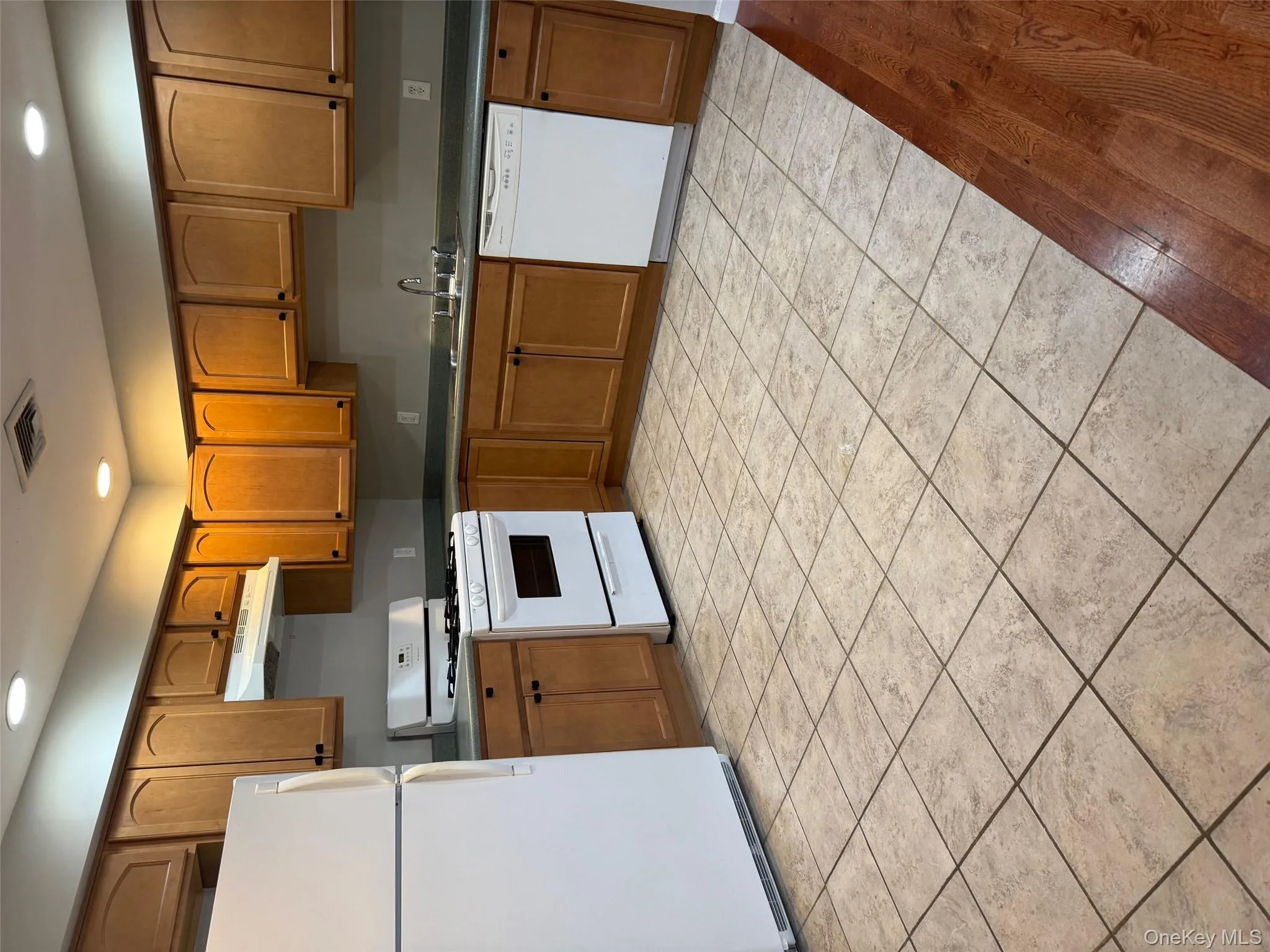 Kitchen with fridge, range, recessed lighting, brown cabinets, and dishwashing machine Kitchen with fridge, range, recessed lighting, brown cabinets, and dishwashing machine