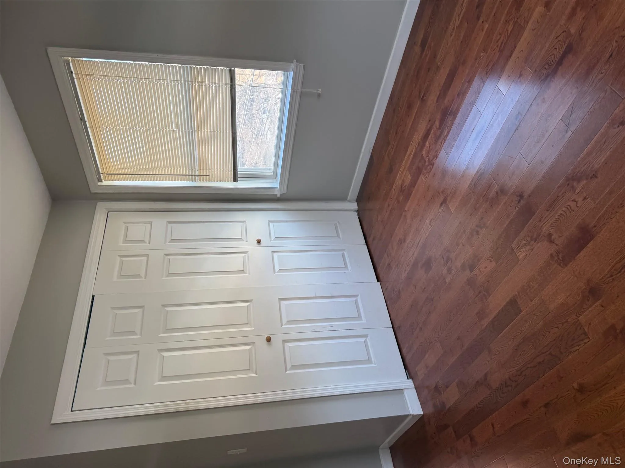 Unfurnished bedroom with dark wood-style floors and a closet Unfurnished bedroom with dark wood-style floors and a closet
