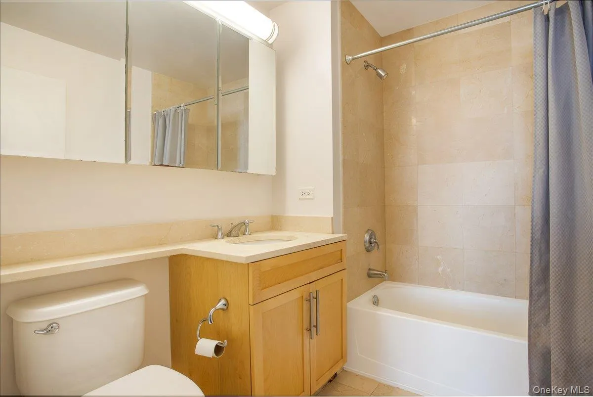 Full bathroom featuring shower / bath combination with curtain and vanity Full bathroom featuring shower / bath combination with curtain and vanity