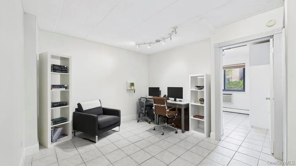 Office with a baseboard heating unit and light tile patterned floors Office with a baseboard heating unit and light tile patterned floors