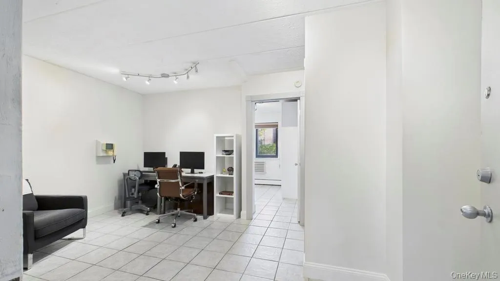 Office area featuring light tile patterned floors and a baseboard heating unit Office area featuring light tile patterned floors and a baseboard heating unit