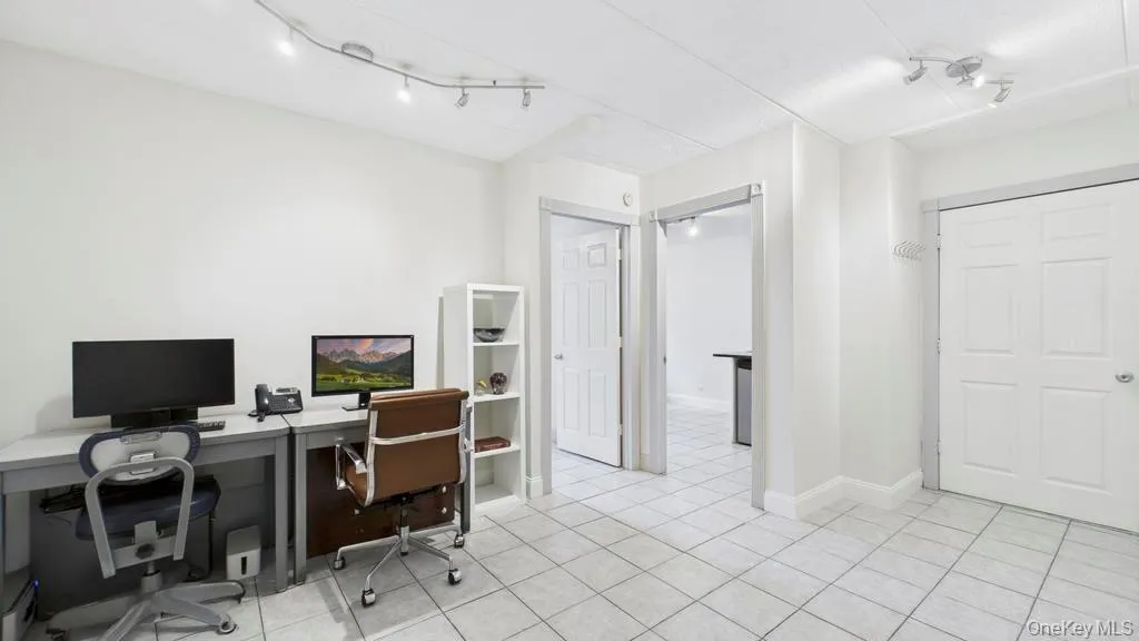 Office area featuring light tile patterned flooring and baseboards Office area featuring light tile patterned flooring and baseboards