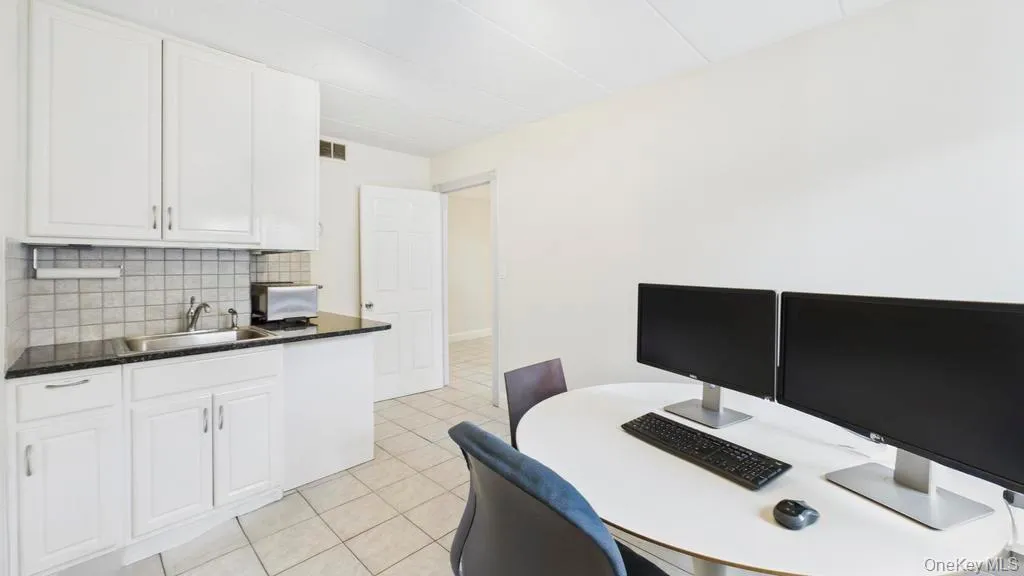 Home office with light tile patterned flooring and a sink Home office with light tile patterned flooring and a sink