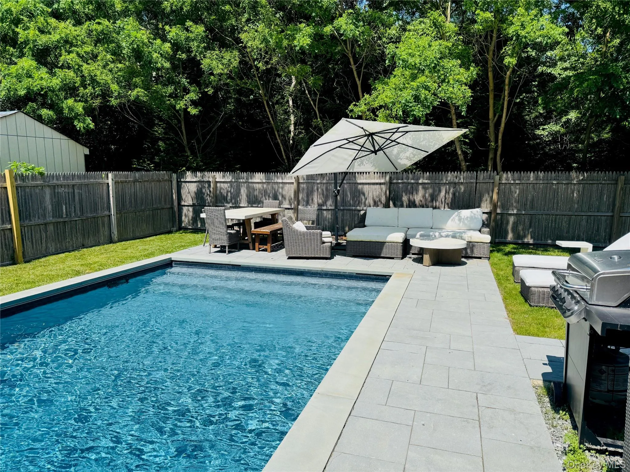 View of pool featuring an outdoor living space, area for grilling, a fenced backyard, and a patio area View of pool featuring an outdoor living space, area for grilling, a fenced backyard, and a patio area