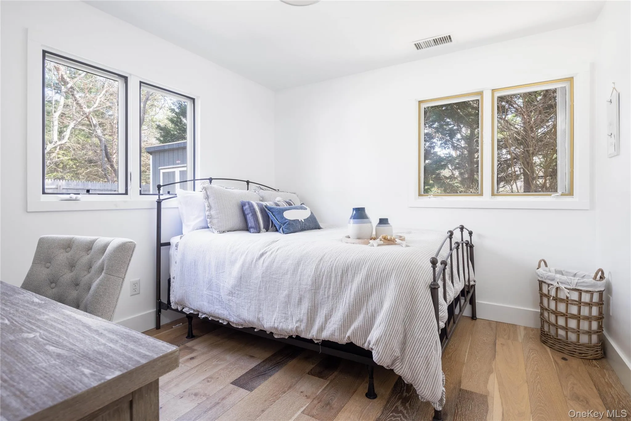 Bedroom featuring light wood-style flooring and multiple windows Bedroom featuring light wood-style flooring and multiple windows