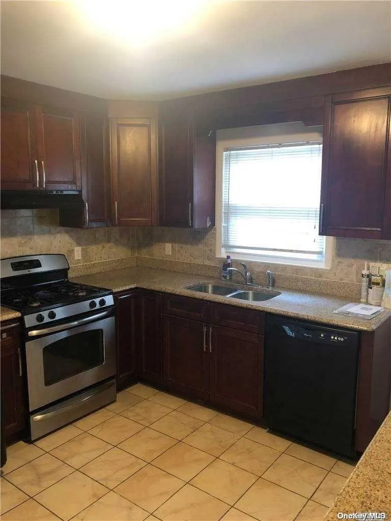 Kitchen featuring gas stove, dark brown cabinetry, sink, light tile patterned floors, and black dishwasher Kitchen featuring gas stove, dark brown cabinetry, sink, light tile patterned floors, and black dishwasher
