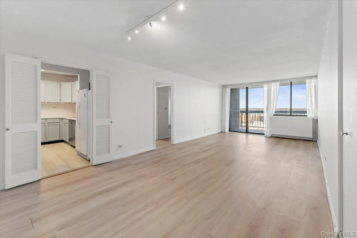 Unfurnished living room with light wood finished floors and baseboards Unfurnished living room with light wood finished floors and baseboards