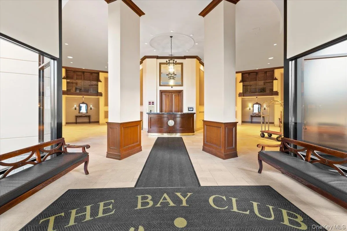 Community lobby with wainscoting, a towering ceiling, a decorative wall, and recessed lighting Community lobby with wainscoting, a towering ceiling, a decorative wall, and recessed lighting