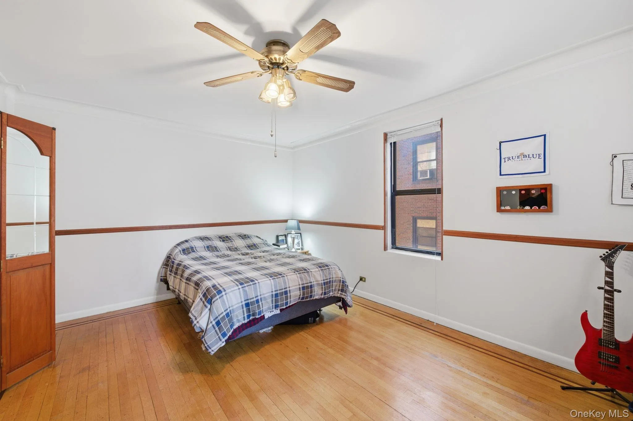 Bedroom featuring ornamental molding, light wood-style floors, and ceiling fan Bedroom featuring ornamental molding, light wood-style floors, and ceiling fan
