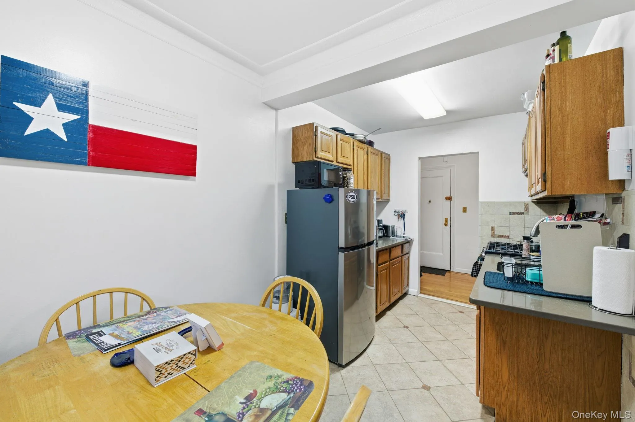 Kitchen featuring appliances with stainless steel finishes, brown cabinets, decorative backsplash, and dark countertops Kitchen featuring appliances with stainless steel finishes, brown cabinets, decorative backsplash, and dark countertops