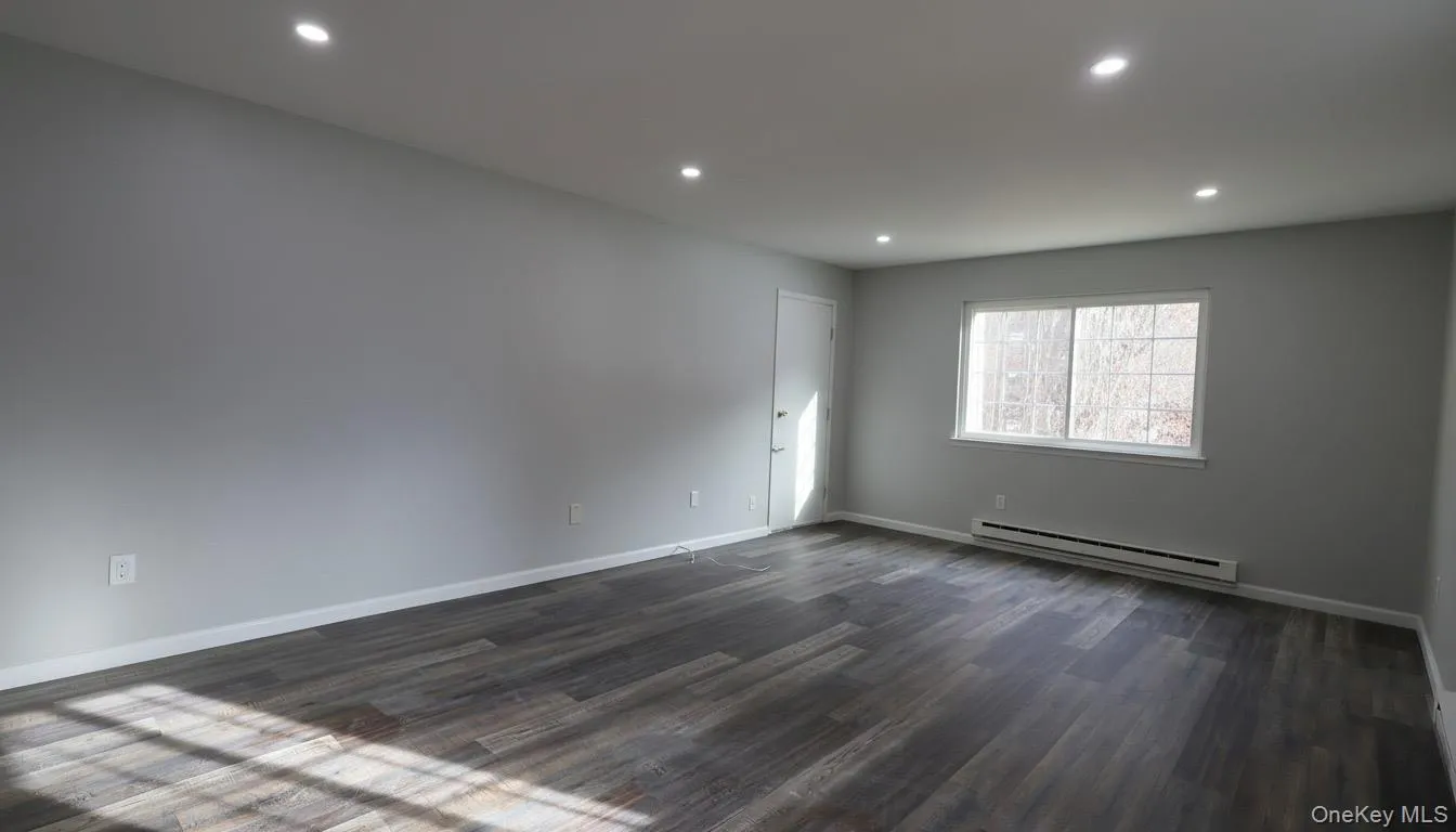 Bright, unfurnished room with cozy baseboard heating, recessed lighting, and sleek vinyl flooring, versatile for any use. Bright, unfurnished room with cozy baseboard heating, recessed lighting, and sleek vinyl flooring, versatile for any use.